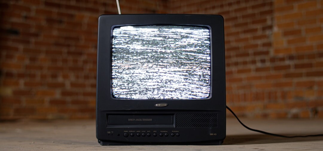 Grey CRT television set on a wooden table in a living room